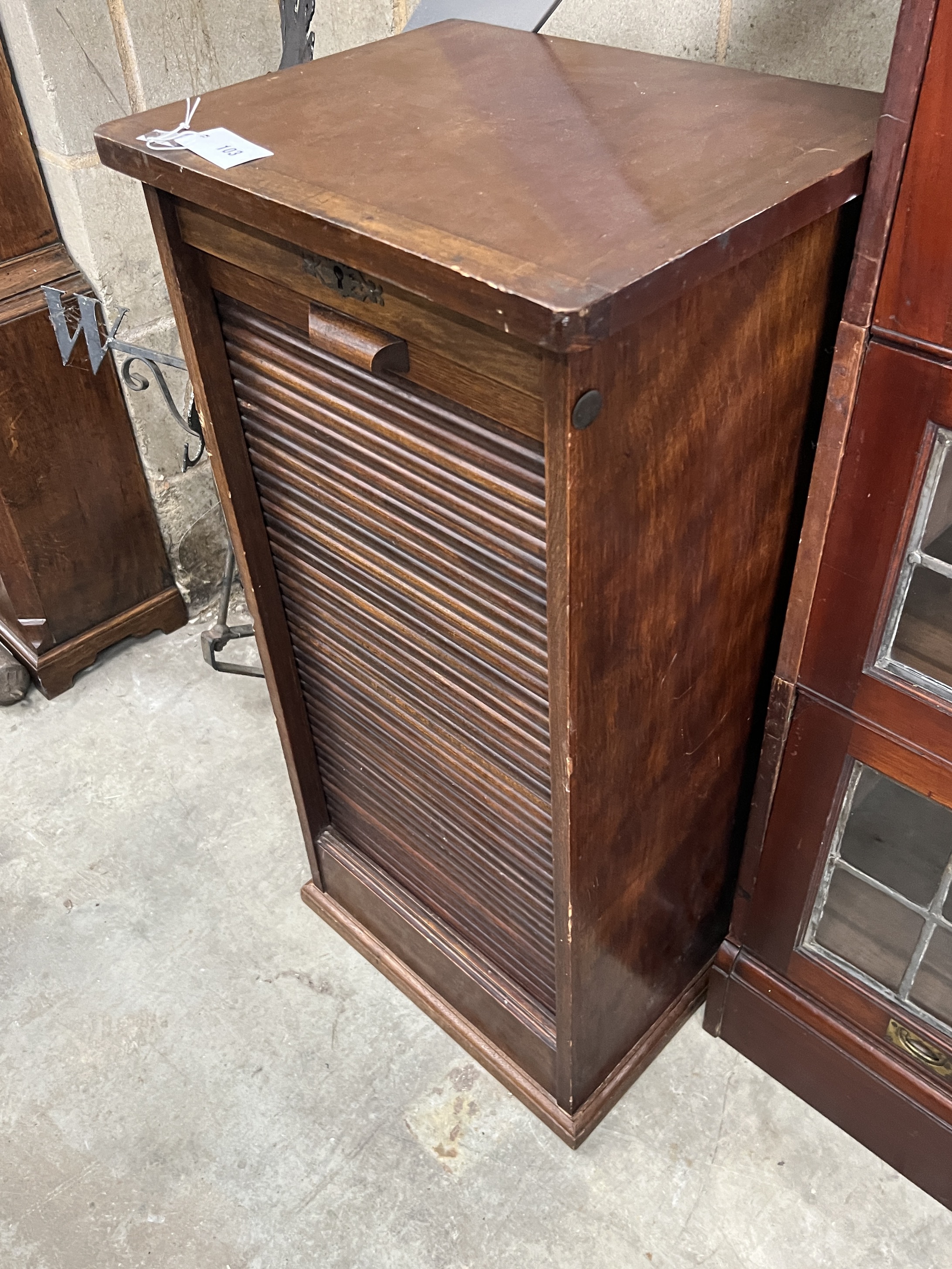 A 1920's oak cabinet with tambour front, width 45cm, depth 36cm, height 92cm